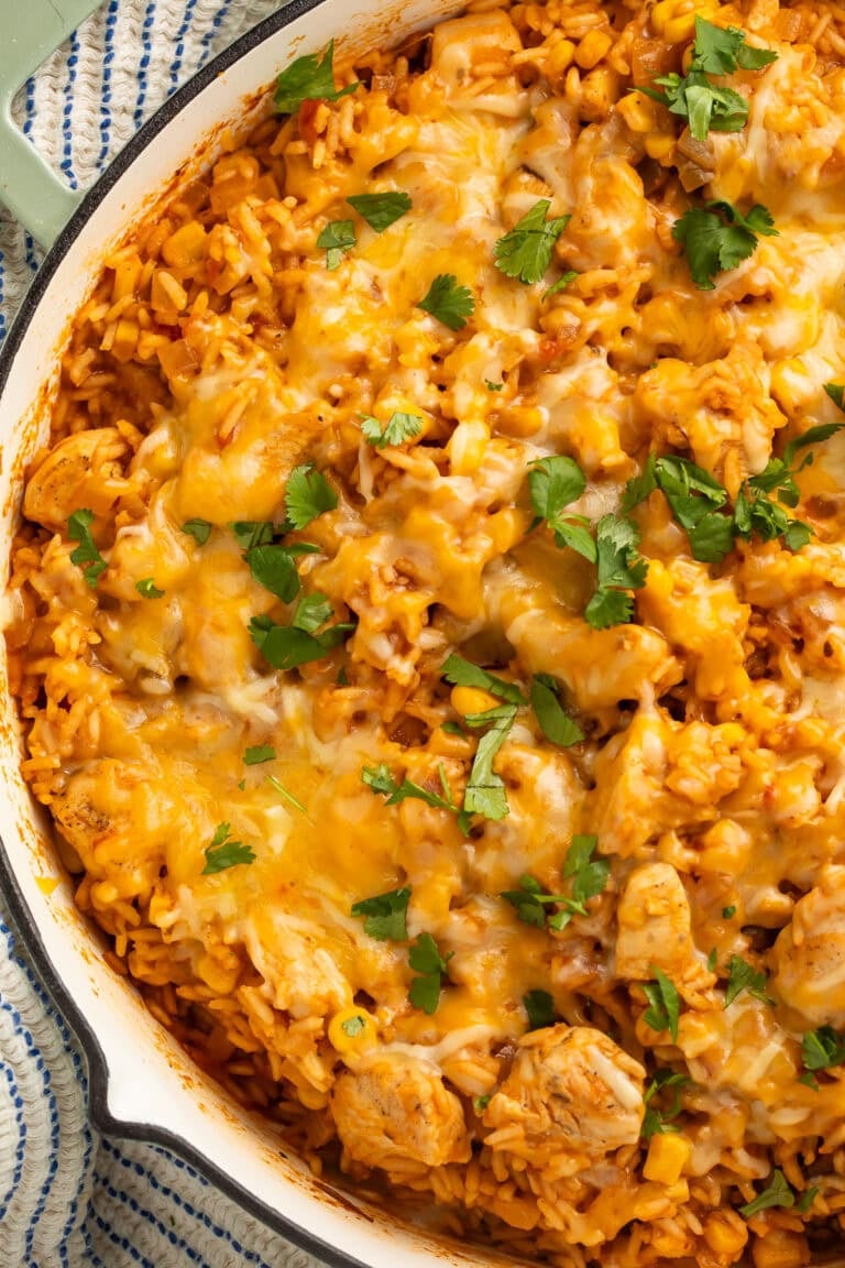 One pan Mexican chicken and rice in a large skillet garnished with fresh cilantro leaves.
