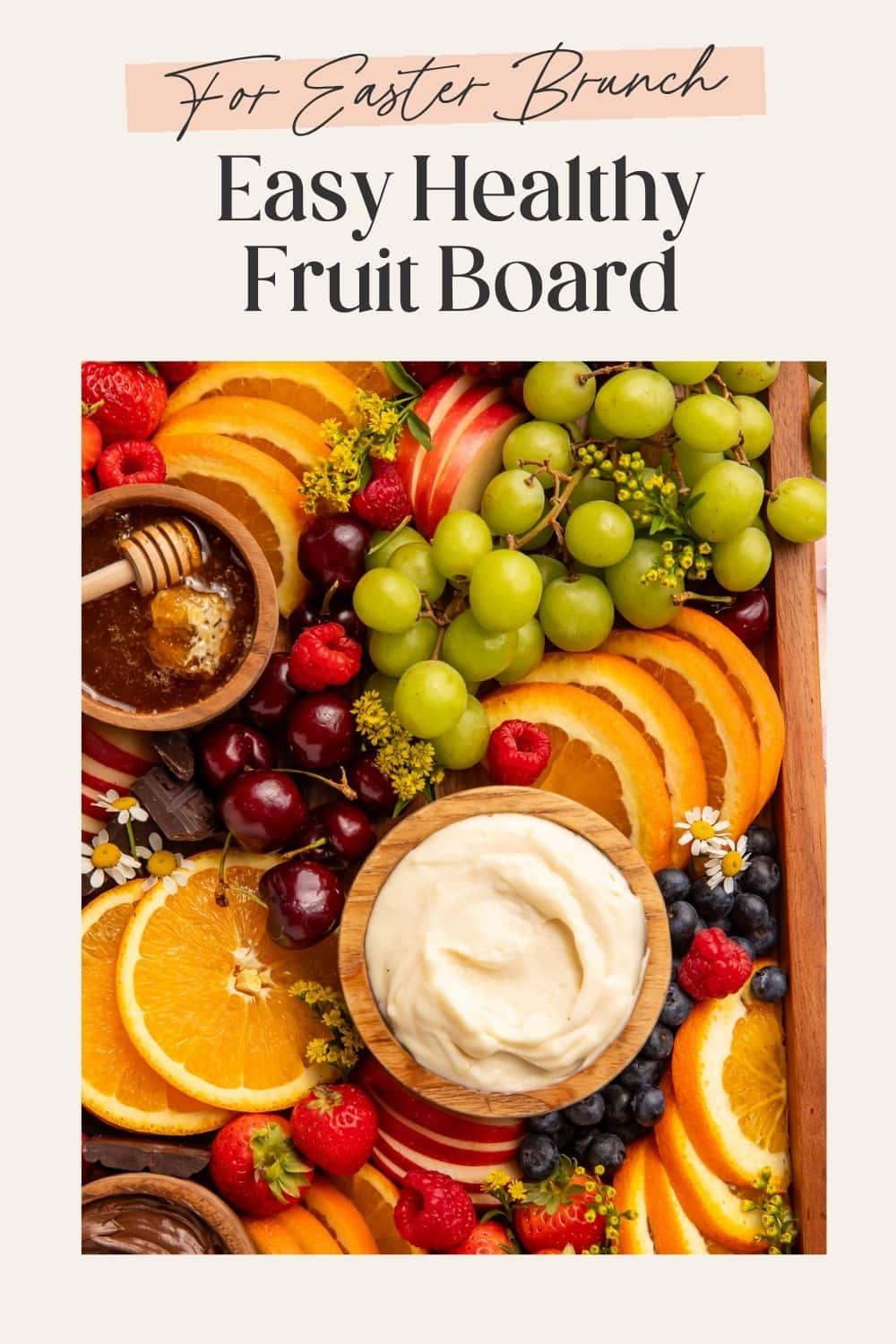 Pinterest pin of an Easter brunch fruit board with orange slices, green grapes, cherries, berries, honey, and cream cheese dip