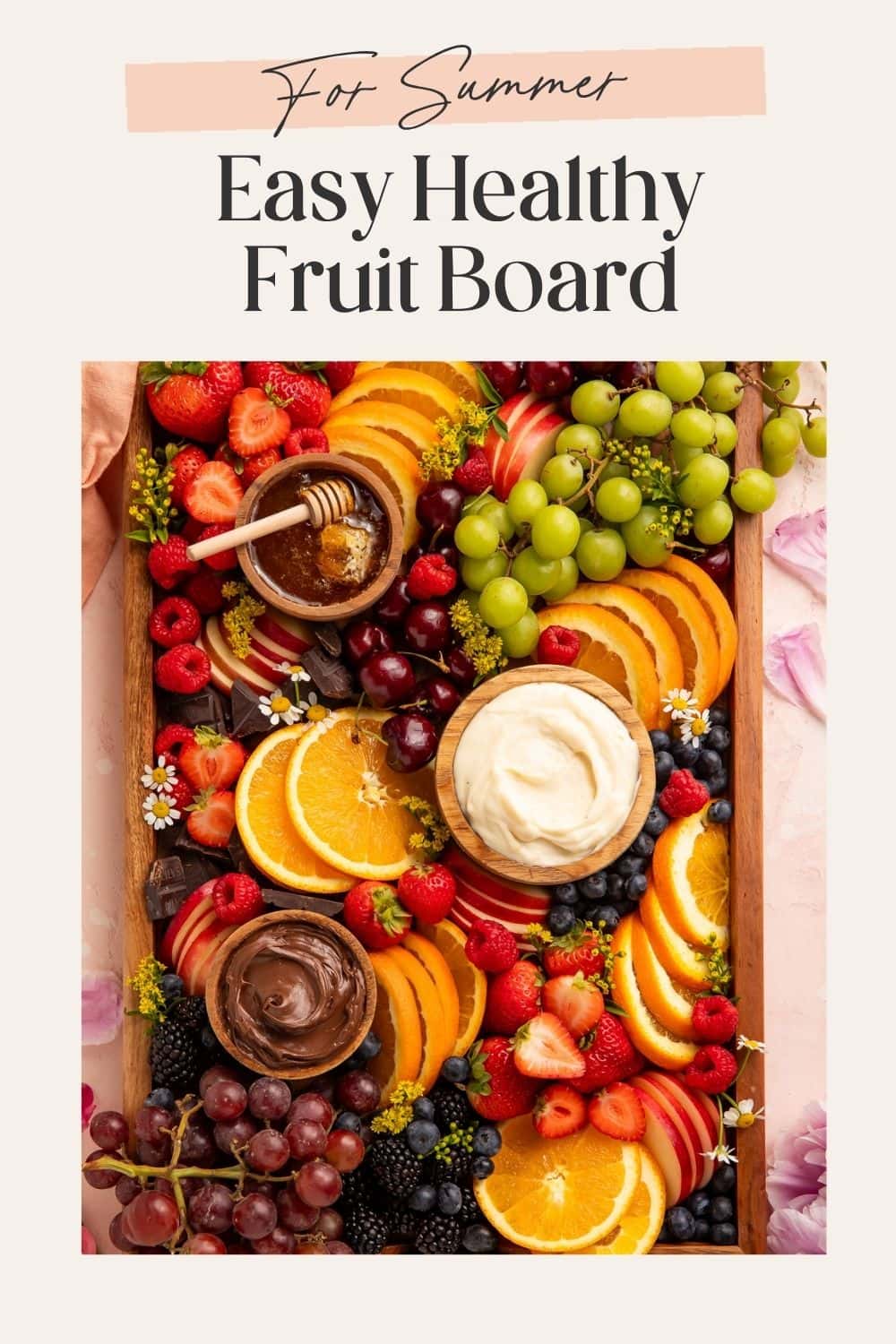 Pinterest pin of a summer fruit board with orange slices, mixed berries, green and red grapes, and three dipping bowls on a wooden tray