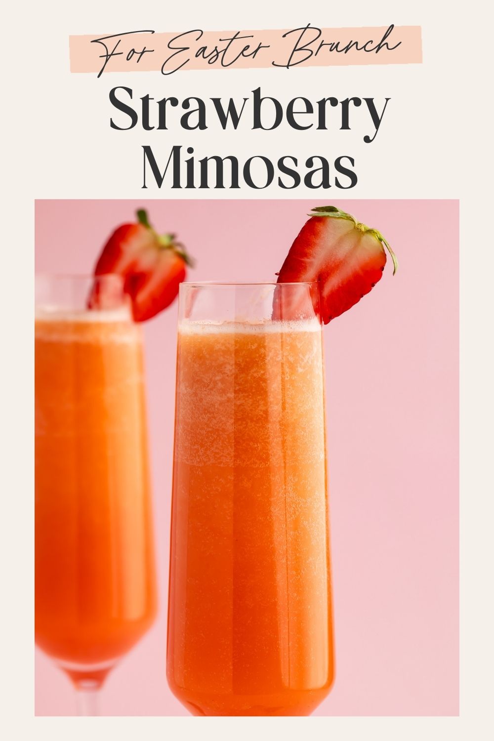 Two strawberry mimosas in champagne flutes with halved strawberry garnishes and Easter Brunch text overlay on pink background