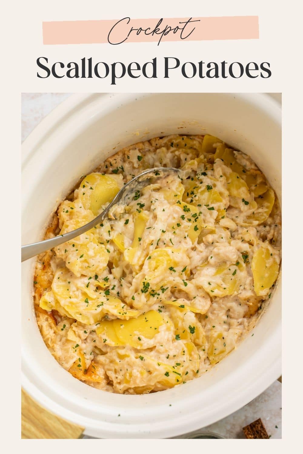 Pinterest pin showing an overhead view of crockpot scalloped potatoes being scooped with a spoon in a white oval slow cooker, with "Crockpot Scalloped Potatoes" text overlay