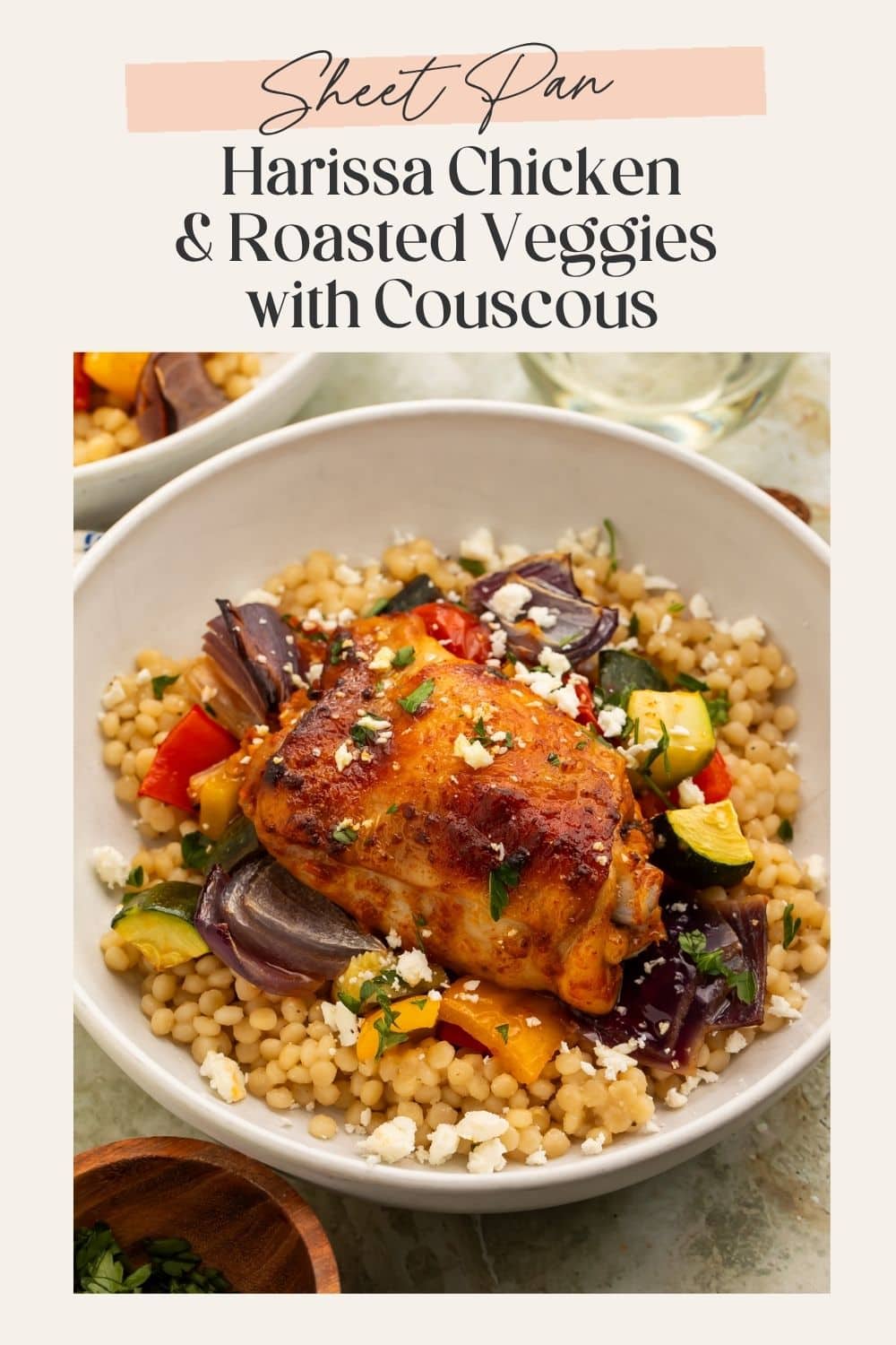 Side-on view of a bowl of couscous, chicken and roasted vegetables, with feta sprinkled on top. There is a frame on the image with a Pinterest-optimised text overlay.