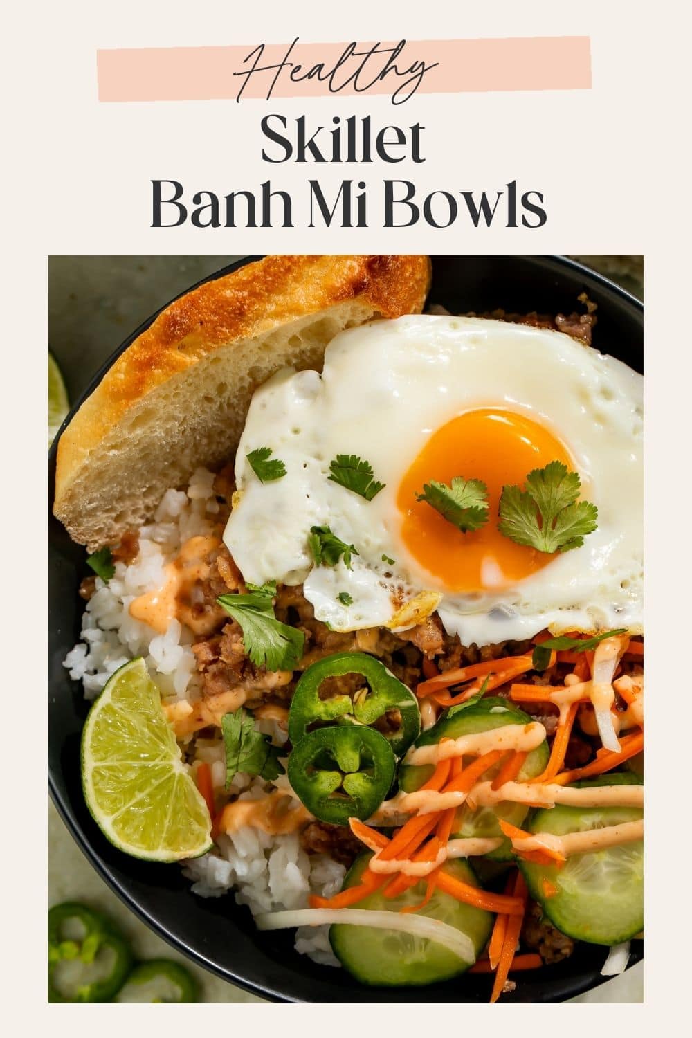 Healthy skillet banh mi bowls with rice, fried egg, cucumber, pickled vegetables, jalapeños, and cilantro