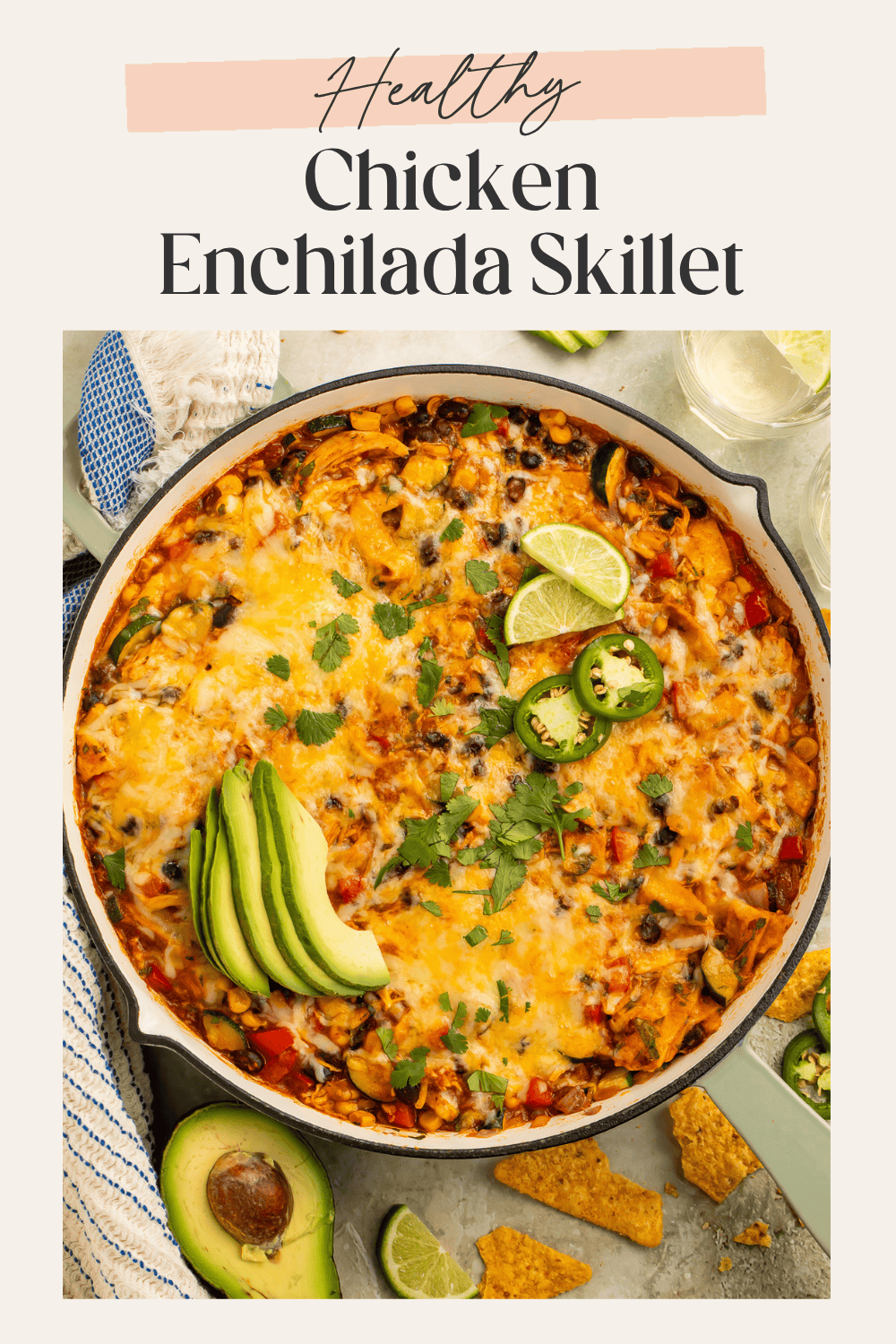 Pinterest graphic for healthy chicken enchilada skillet topped with melted cheese, avocado, jalapeños, cilantro, and lime.