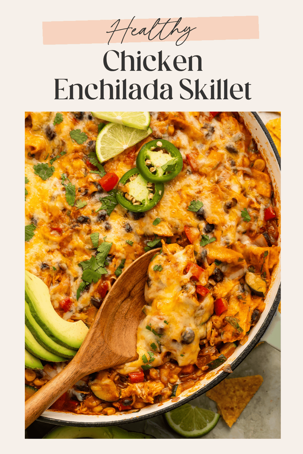 Close-up Pinterest pin of cheesy chicken enchilada skillet with jalapeños, lime wedges, avocado, and cilantro