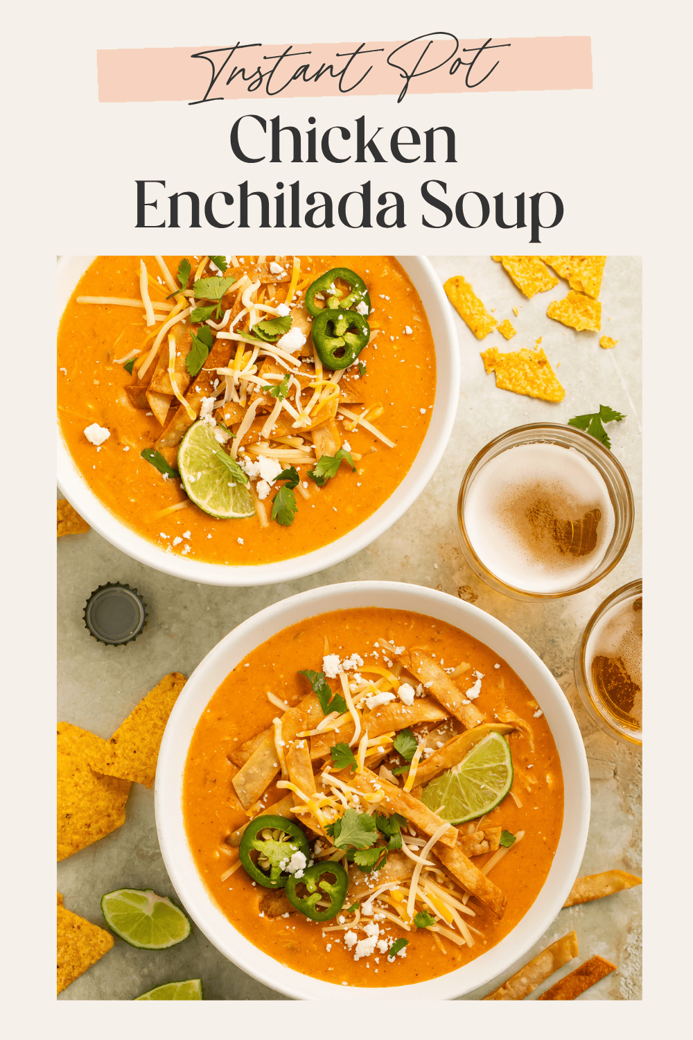 Overhead shot of two bowls of chicken enchilada soup surrounded by tortilla chips and beer