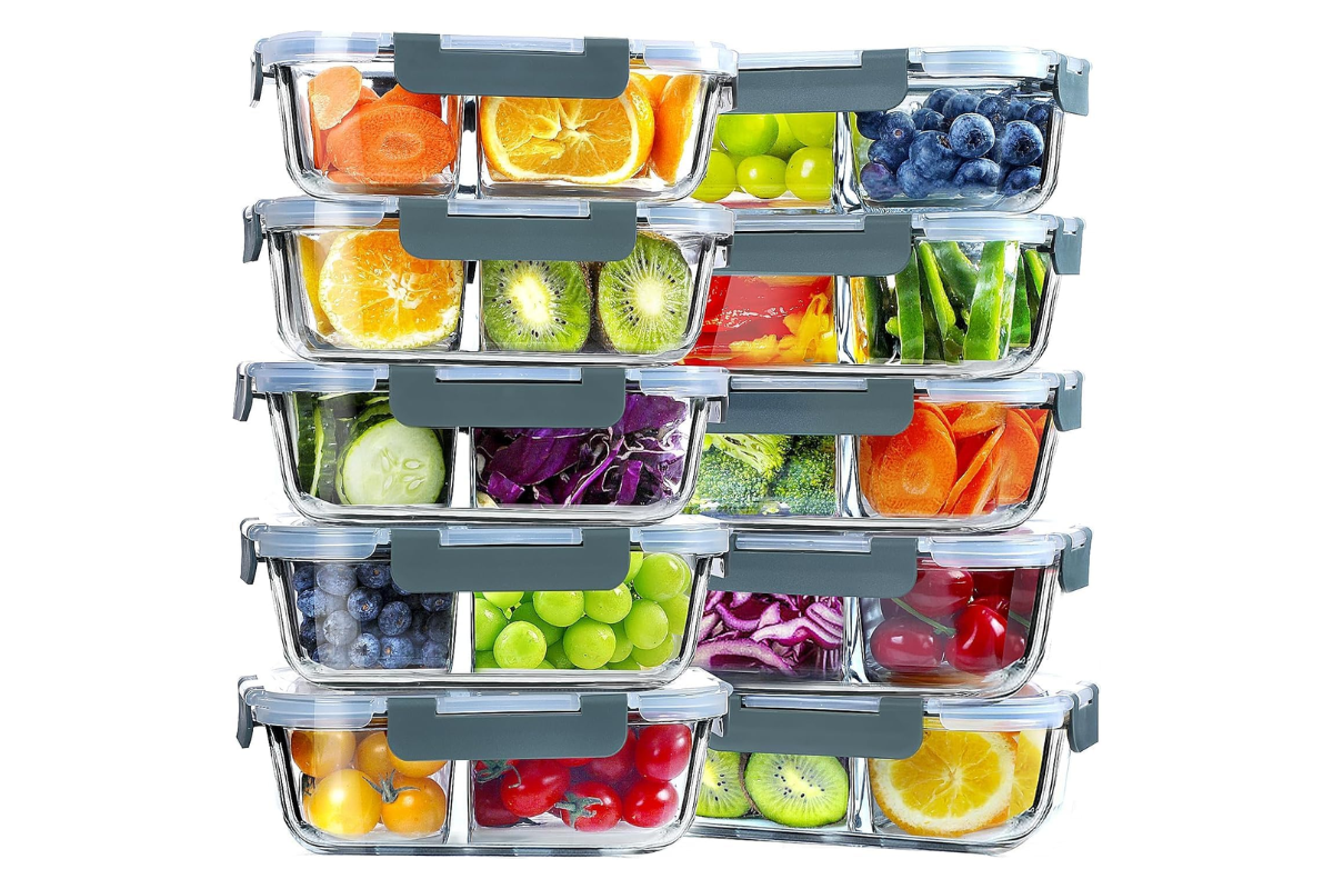 Stacked glass food storage containers with divided compartments filled with fresh fruits and vegetables