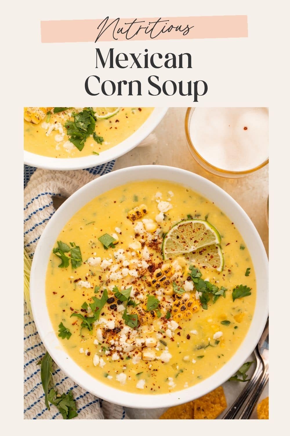 Close up of a bowl of creamy corn soup with a cup of beer on the side. There is a pale pink frame on the image with a Pinterest-optimised text overlay.