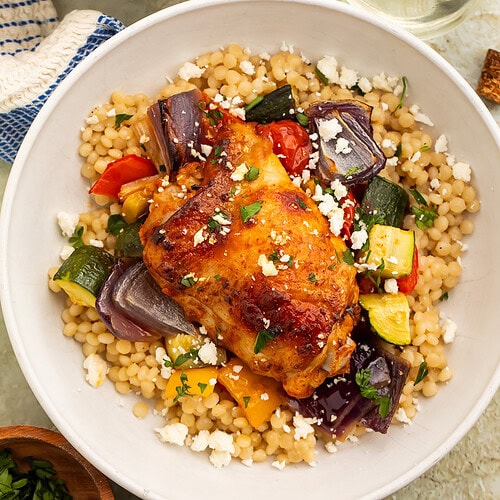 Overhead image of a bowl of couscous topped with harissa chicken and roasted veggies.