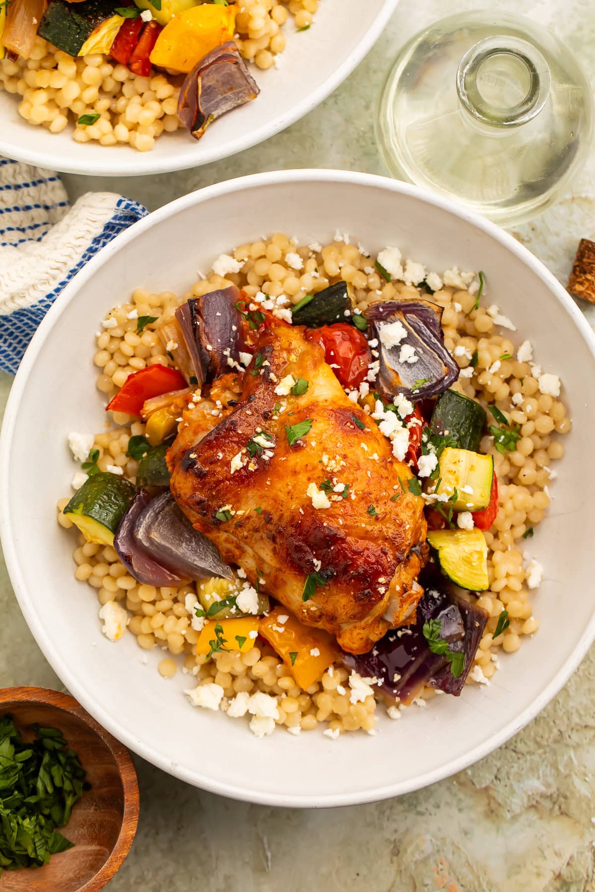 Overhead image of a bowl of couscous topped with harissa chicken and roasted veggies.