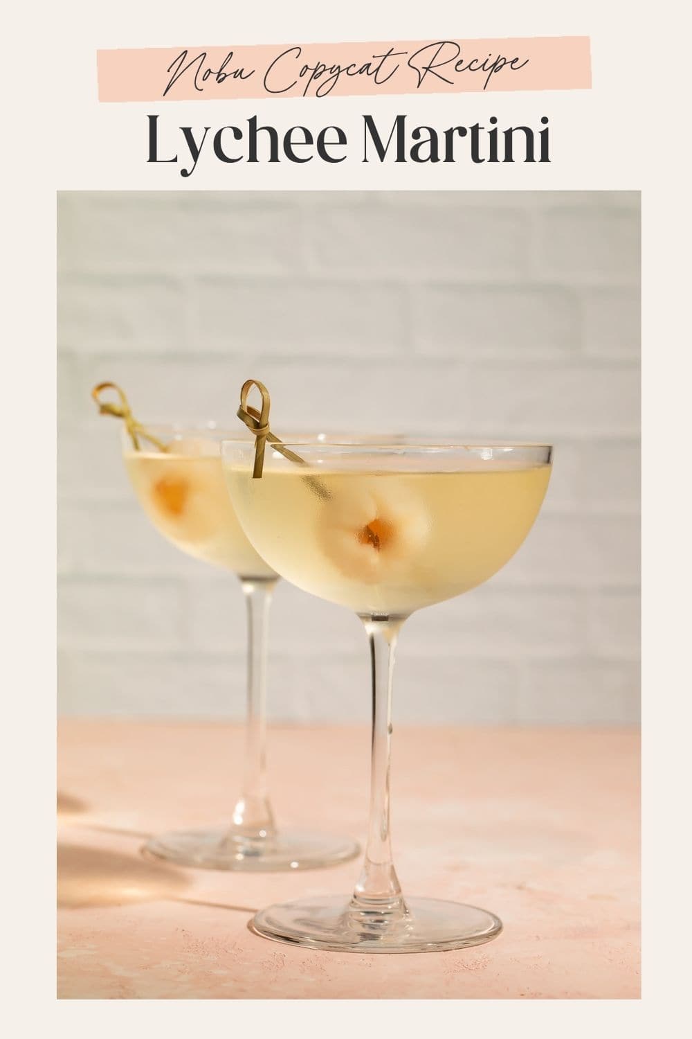 Close up of a pair of lychee martinis garnished with a whole lychee in each glass. There is a frame on the image with Pinterest-optimised text.
