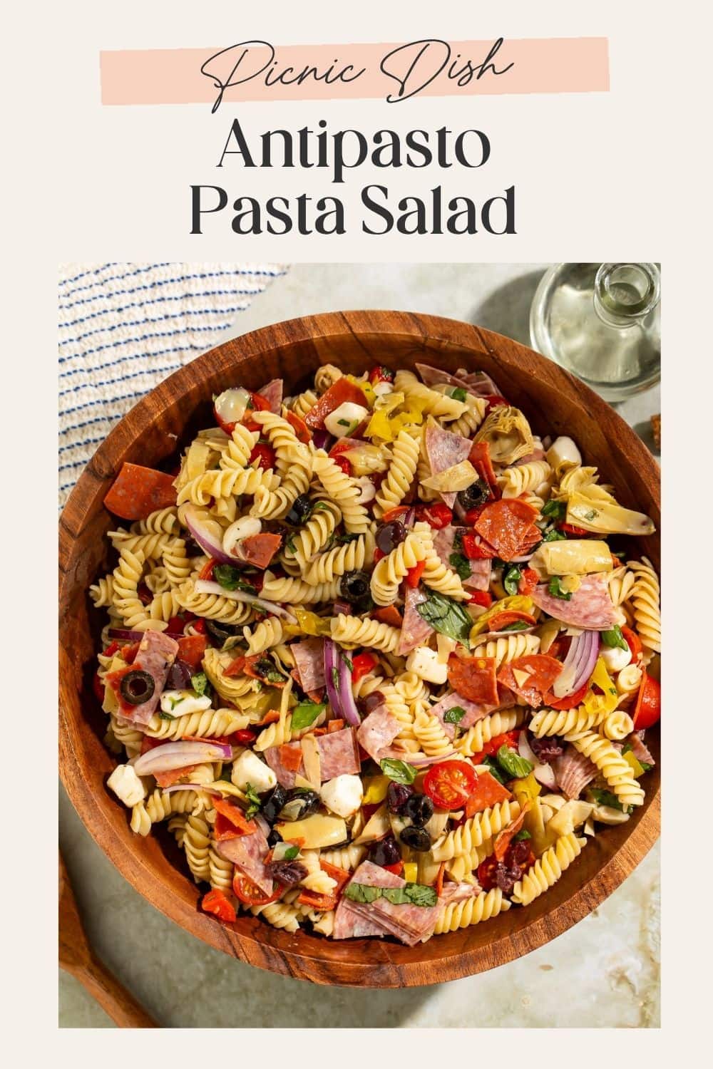 Wooden bowl of antipasto pasta salad with a frame on the image. There is a Pinterest-optimised text overlay.