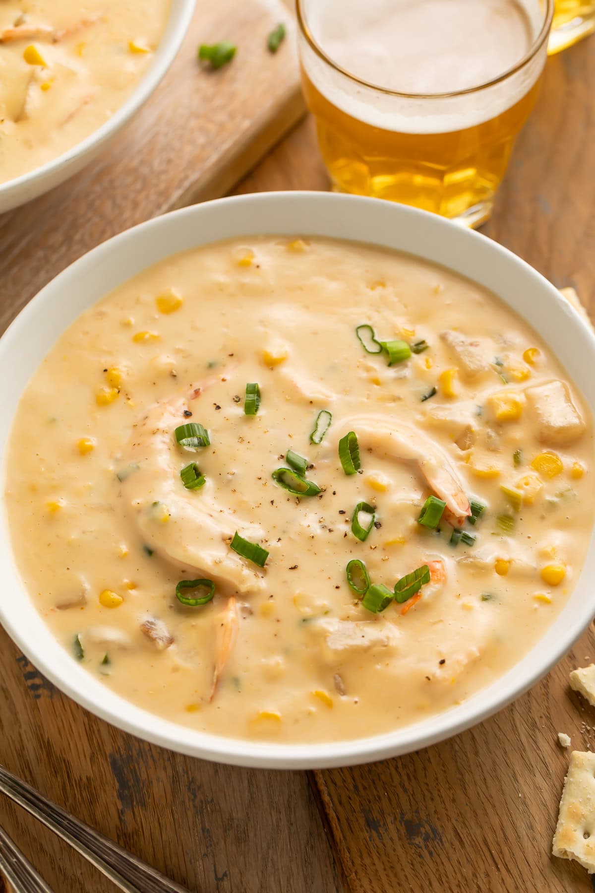 Close up of a bowl of chowder with potatoes, corn and shrimp.