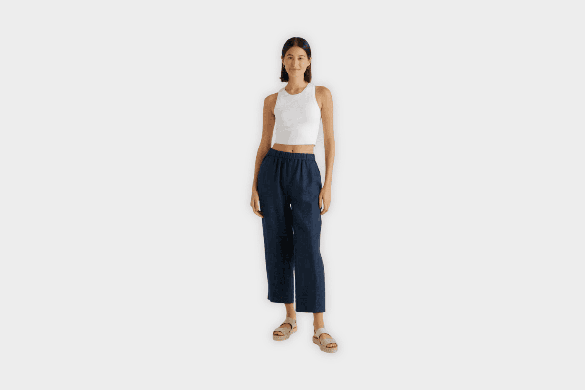 Model wearing Quince deep navy linen wide-leg cropped pants with white crop top and sandals
