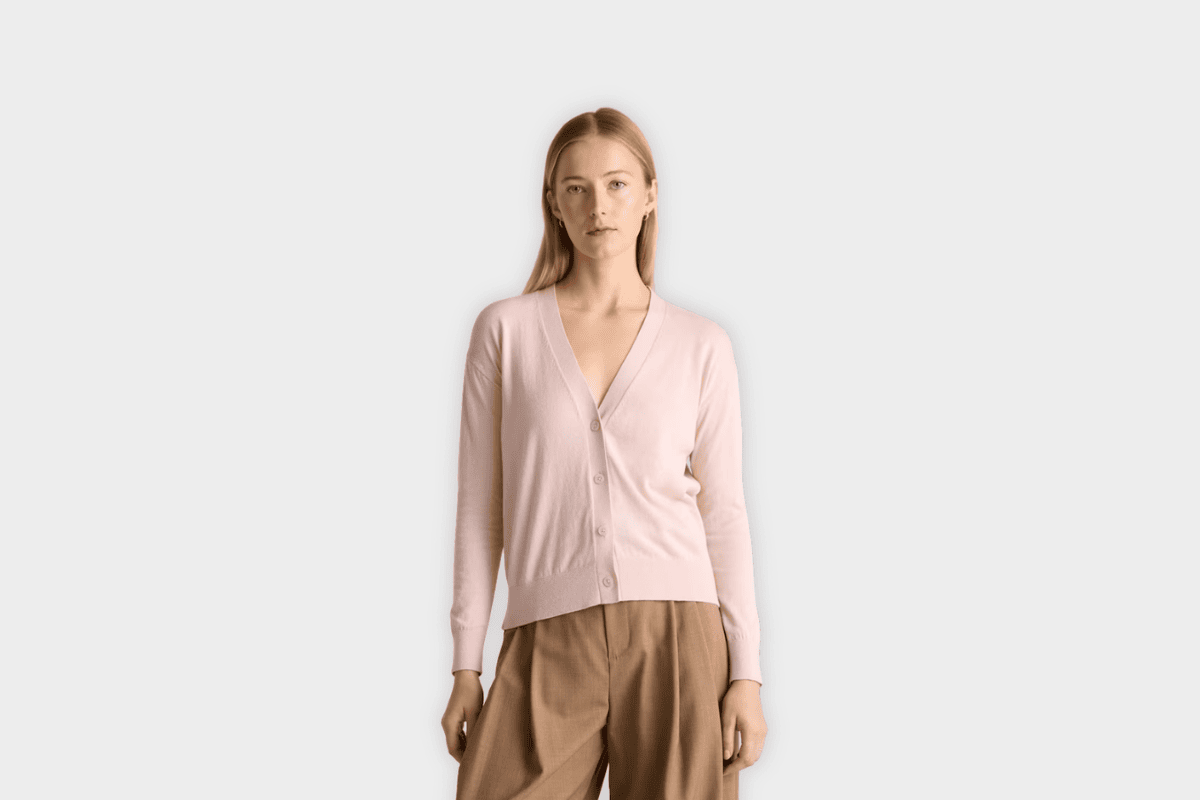 Model wearing Quince light pink cotton cashmere fine gauge v-neck cardigan with button front
