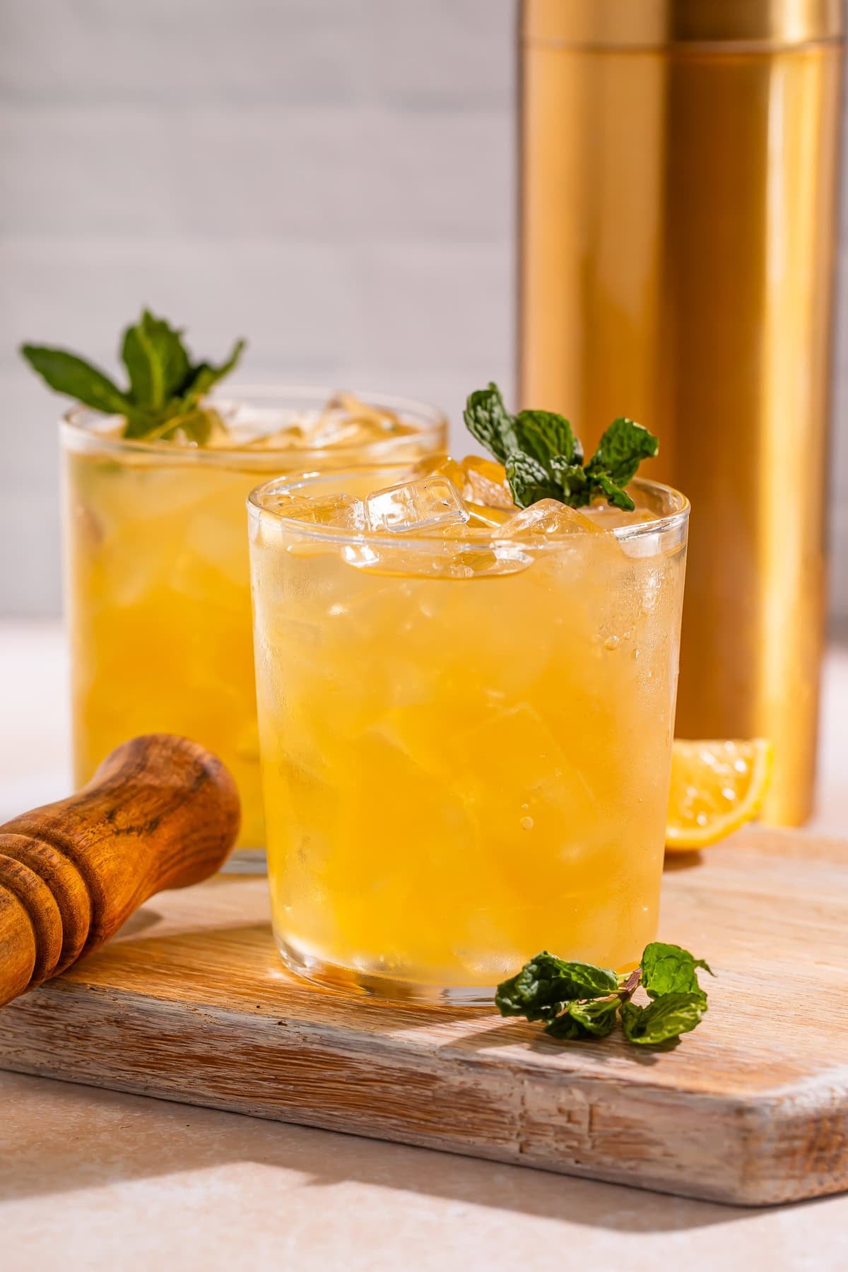 Two Bourbon smashes served on the rocks garnished with fresh mint.