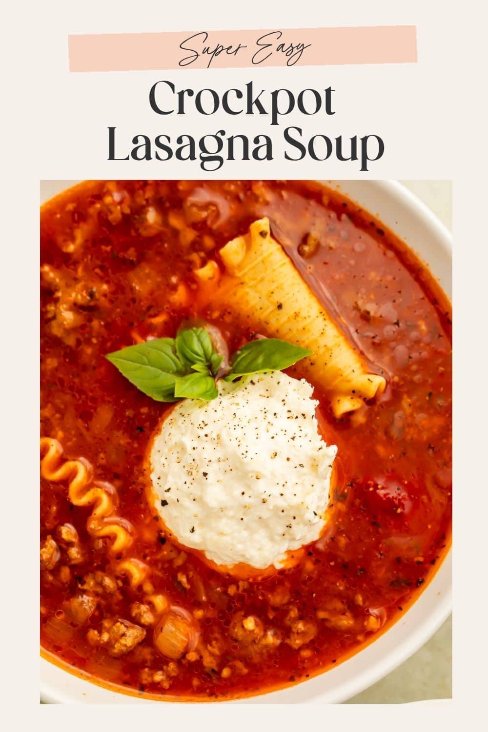 Hyper-close up overhead image of a bowl of lasagna soup with broken lasagna noodles, a scoop of ricotta cheese mix and a fresh basil leaf. There is a frame on the image with Pinterest-optimized text.