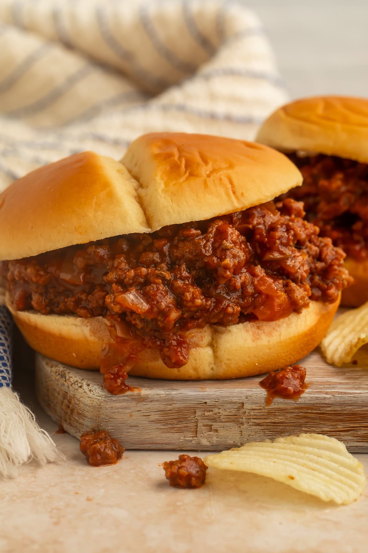 Side-on picture of a crockpot sloppy joe on a wooden board.