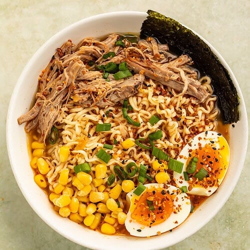 Chipotle pork ramen bowl with soft-boiled egg, corn, scallions, and savory broth