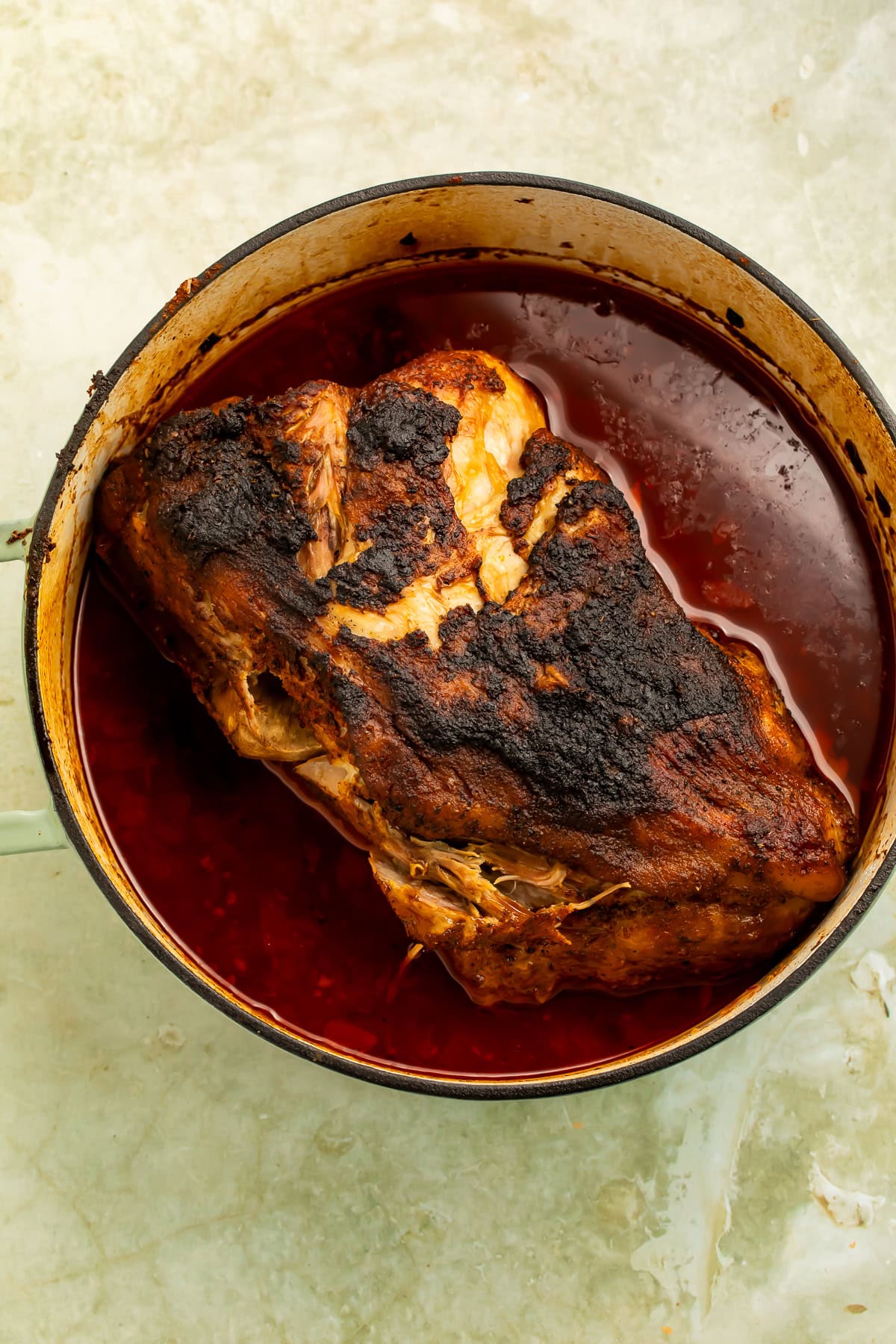 Chipotle braised pork shoulder seared until deeply browned and braising in a Dutch oven with smoky chipotle-orange sauce.