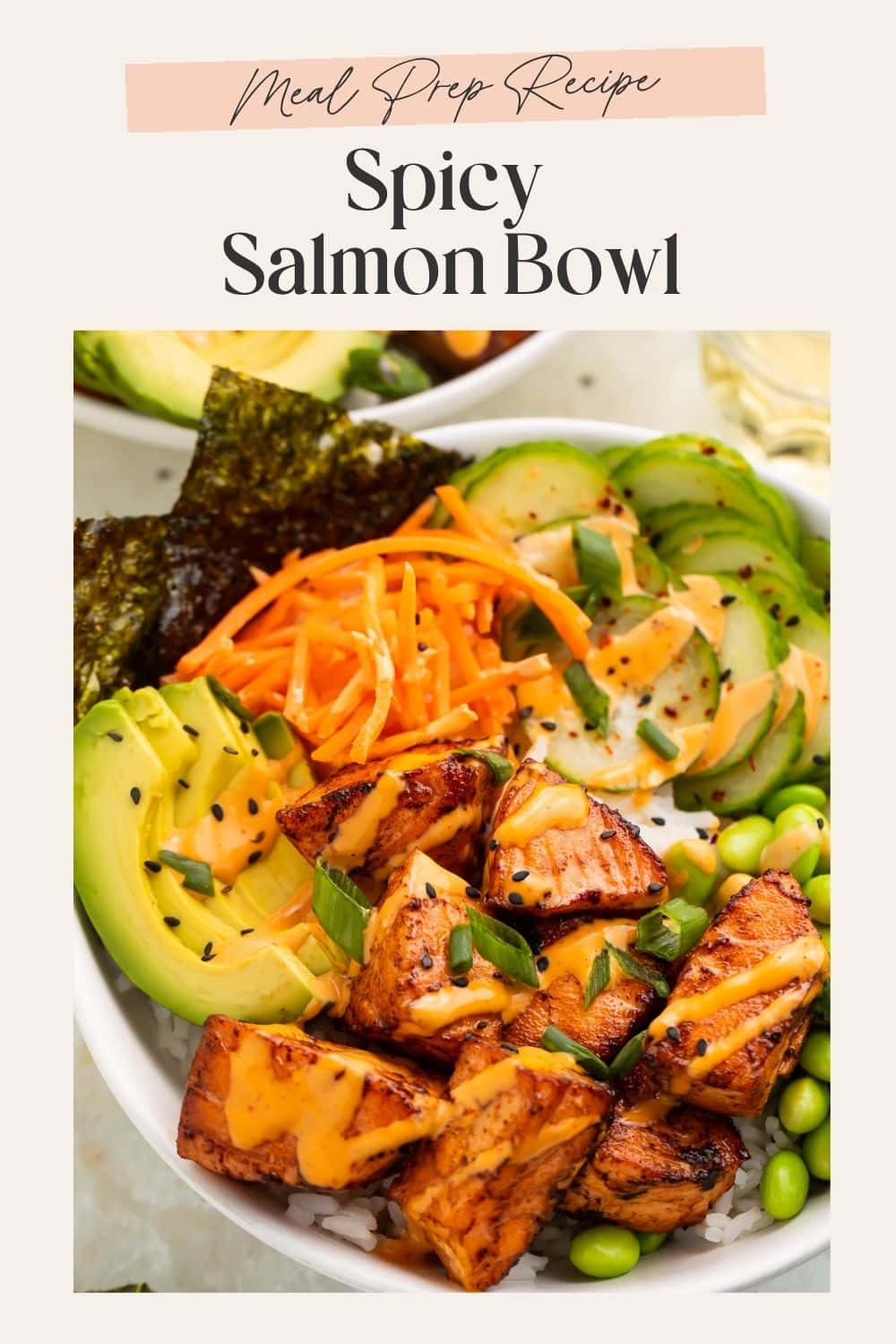 Close up of salmon bites on a rice bowl with sliced avocado, cucumber, shredded carrot and nori sheets.