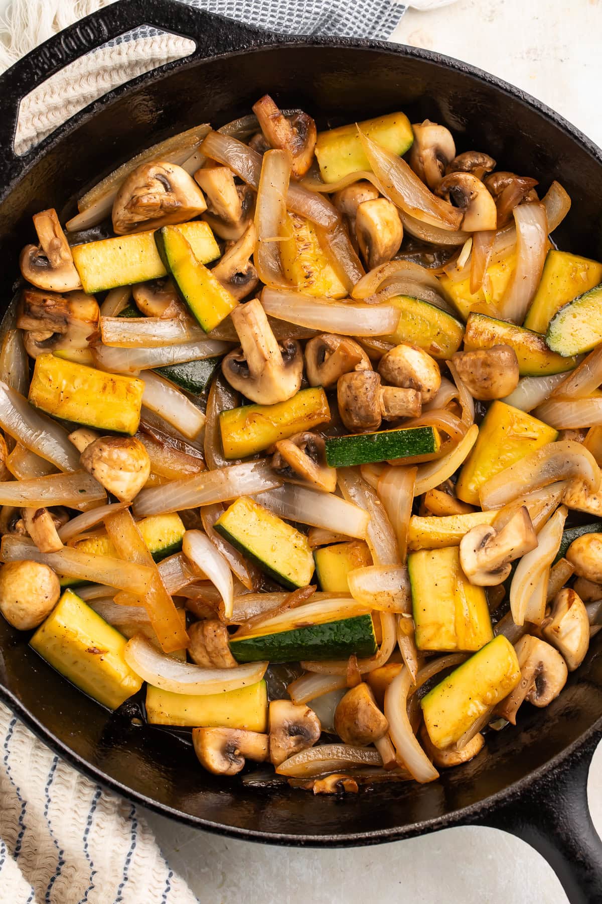 Skillet of well cooked mushrooms, onions and zucchini.