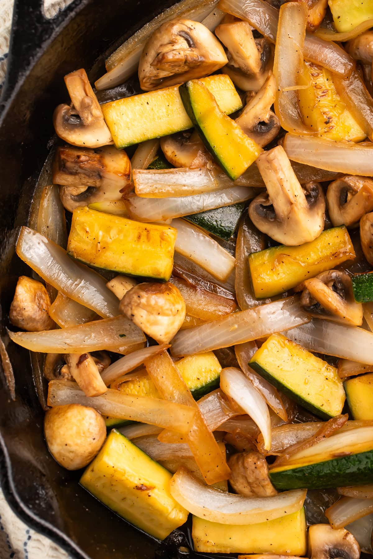 Close up of hibachi mushrooms, zucchini and onions in a cast iron skillet.