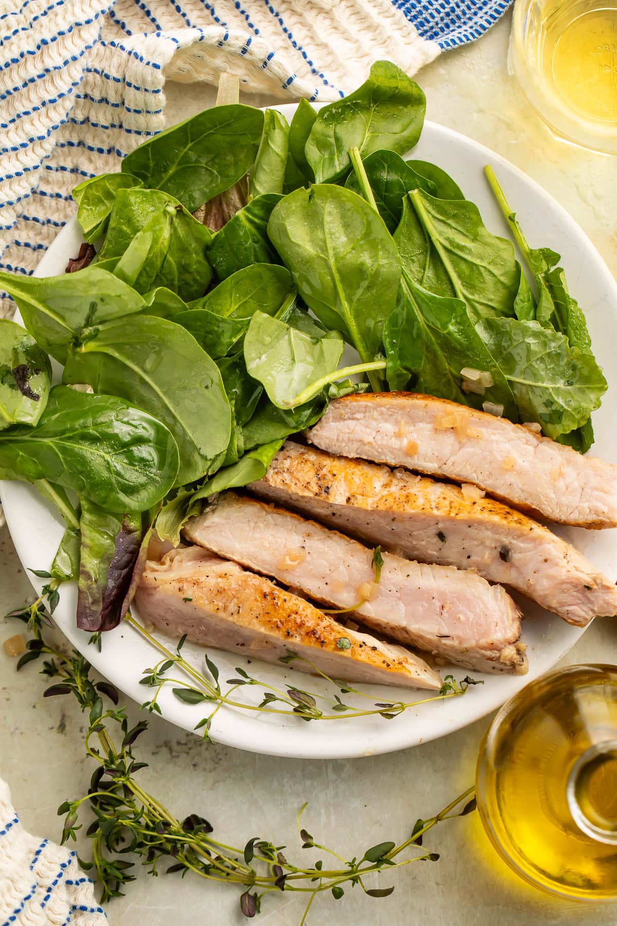 Sliced pork chops on a white plate with a simple side salad.