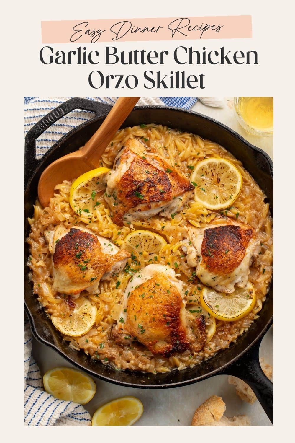 Overhead image of a garlic butter, orzo chicken skillet with lemon slices. There is a frame on the image with Pinterest-friendly text.
