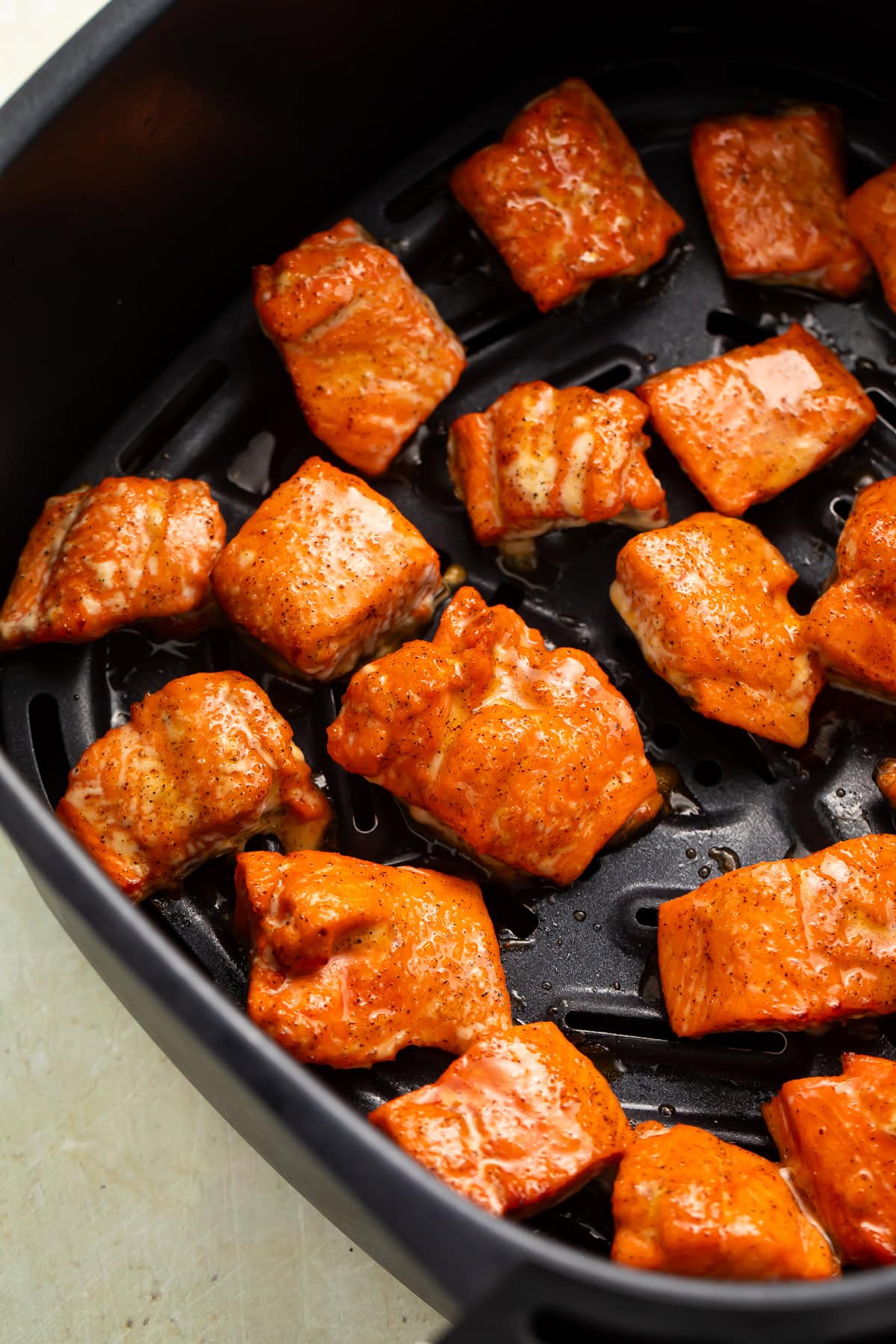 Cajun salmon bites in the air fryer basket.
