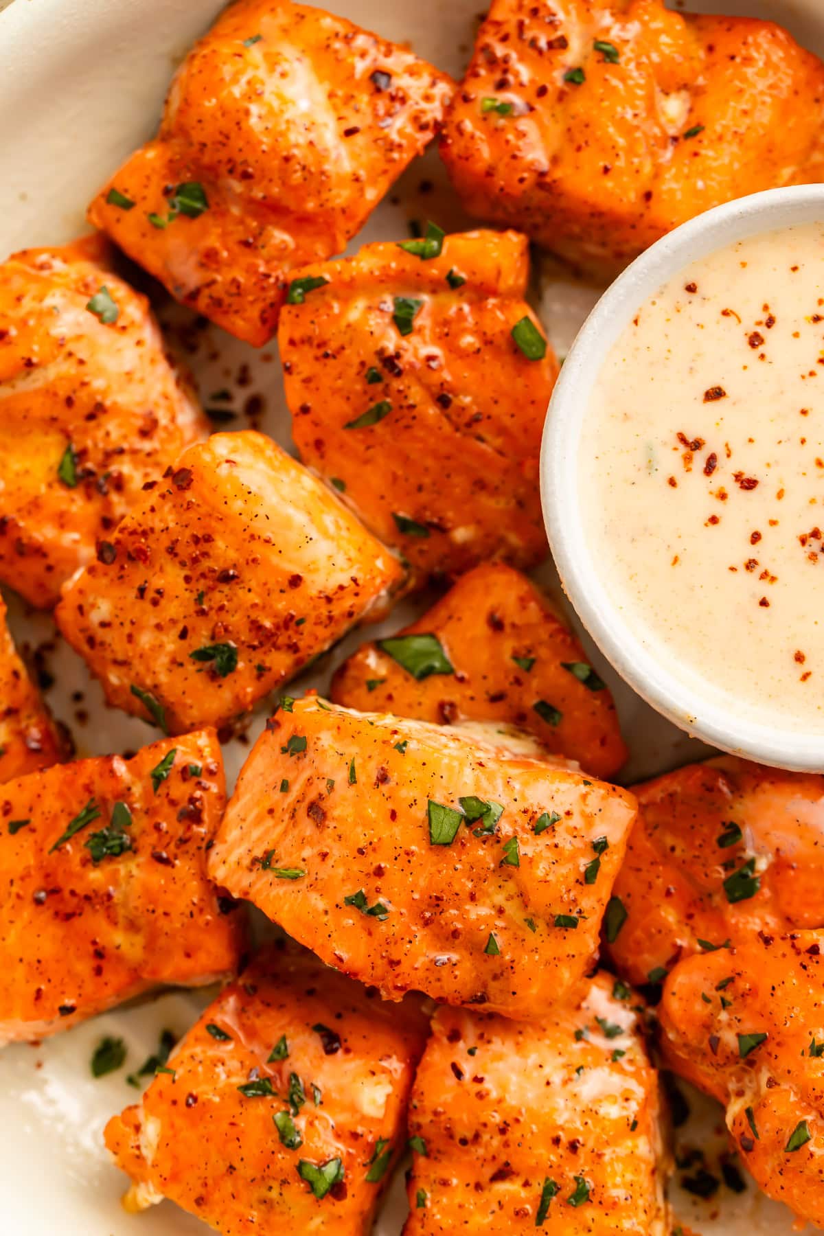 Close up of air fryer cajun honey bites with a bowl of creamy sauce on the side.