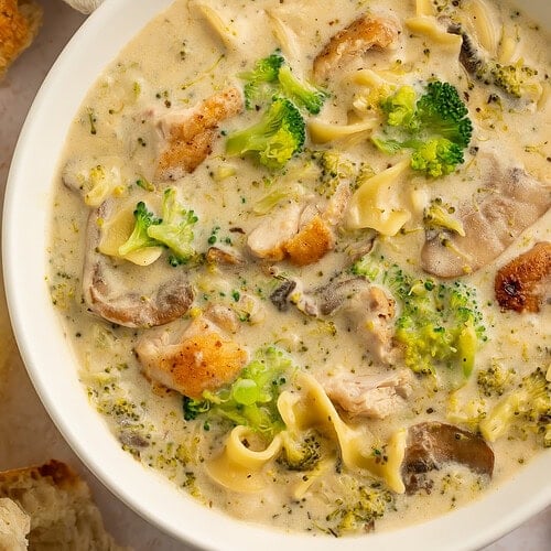 Close up of a white bowl of chicken divan soup.