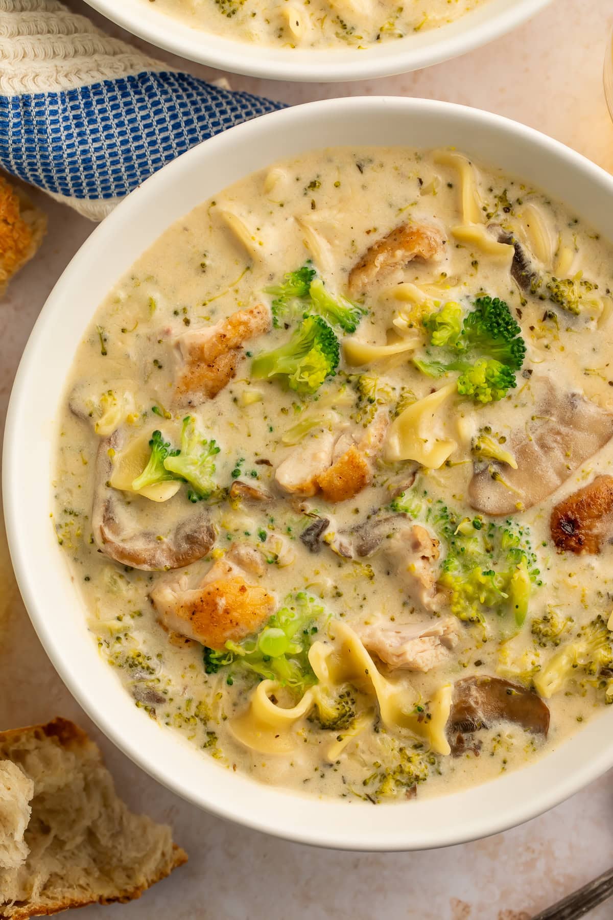 Close up of a white bowl of chicken divan soup.