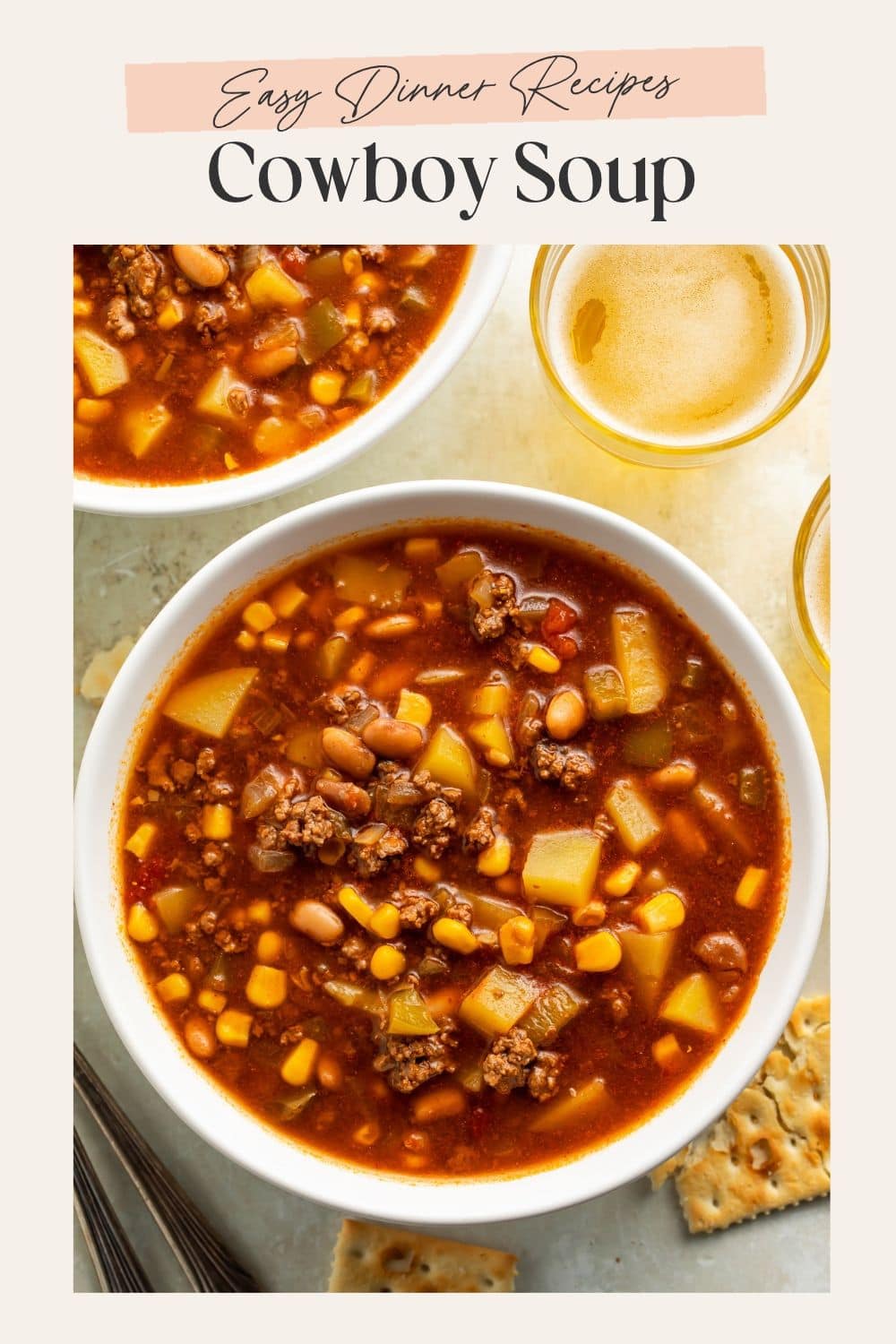 Close up of two bowls of cowboy soup next to cups of beer. There is a frame on the image with Pinterest-friendly text.