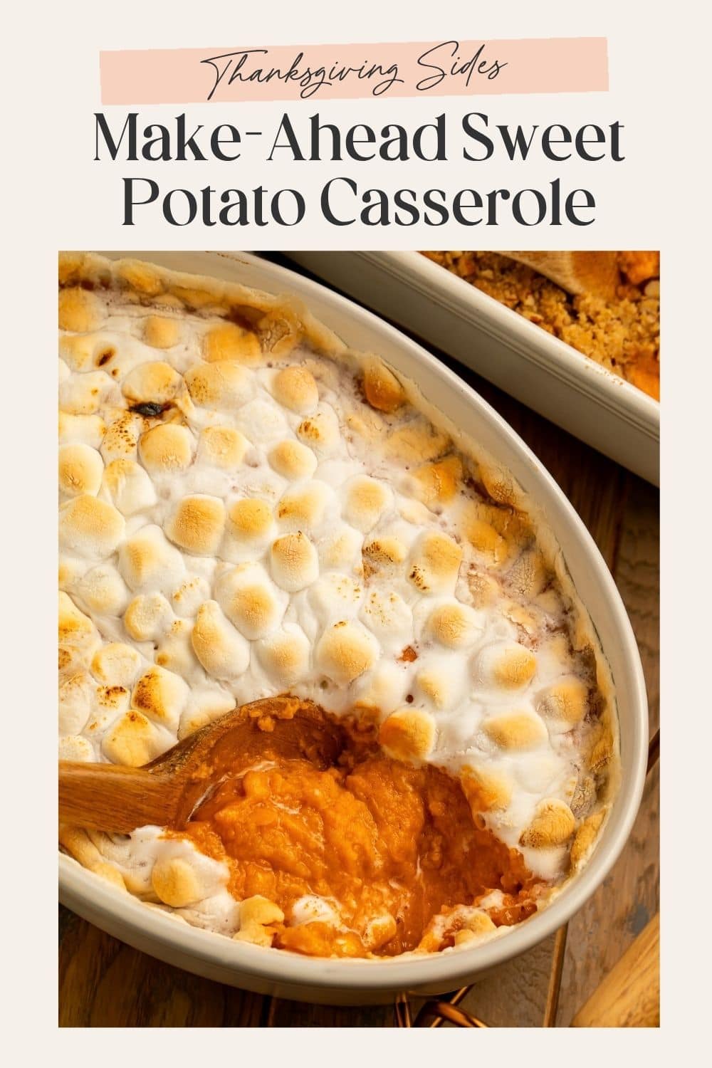 Close up of a sweet potato casserole with marshmallows. There is a spoonful missing to show the sweet potato layer, and a frame with Pinterest-friendly text.