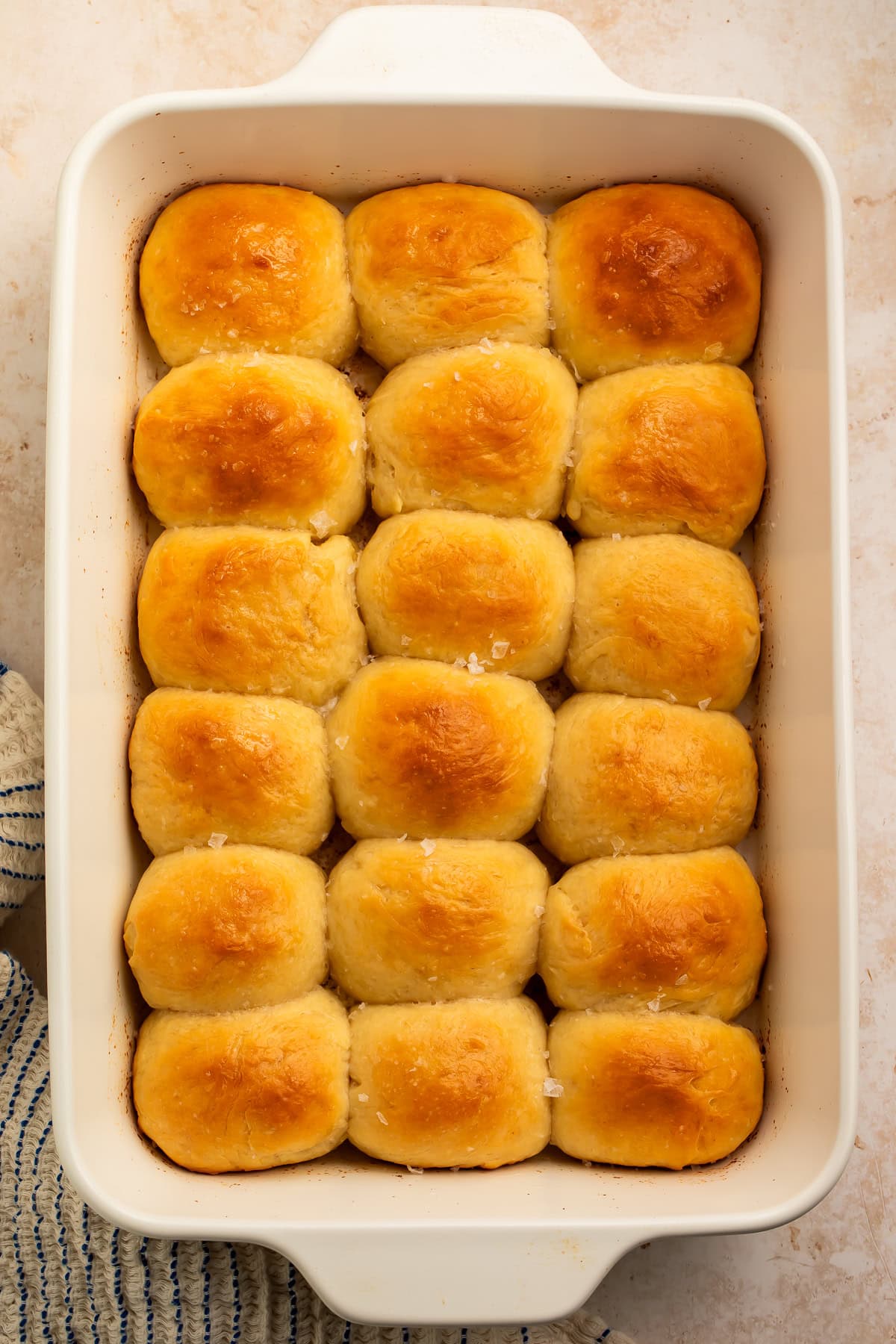 Overhead image of a white pan of 18 parker house rolls.