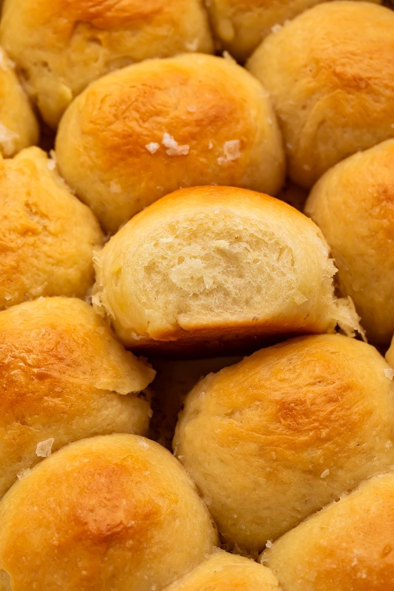 Close up of parker house rolls scattered with flaky sea salt.