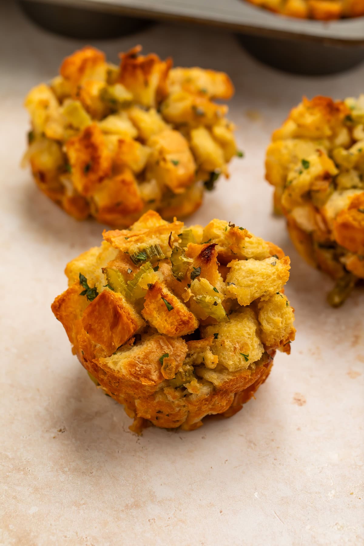 Close up of three stuffing muffins removed from the muffin pan.